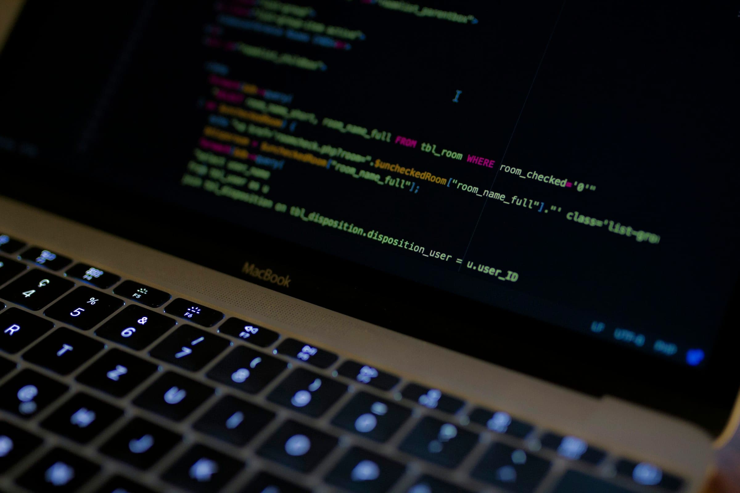 A laptop showing source code in a dark editor